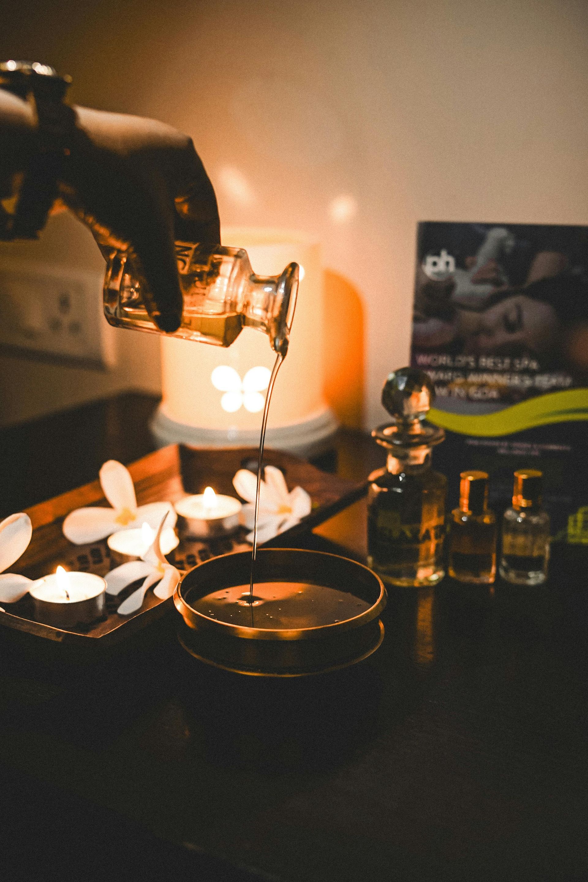 Ambiente de café con iluminación tenue, con una bebida vertiéndose, tazas y botellas de vidrio sobre una mesa.
