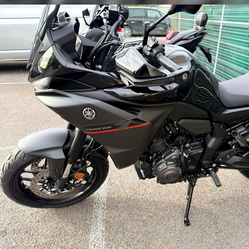 Moto Yamaha sport-touring noire garée à l'extérieur, avec pare-brise et sacoches rigides.