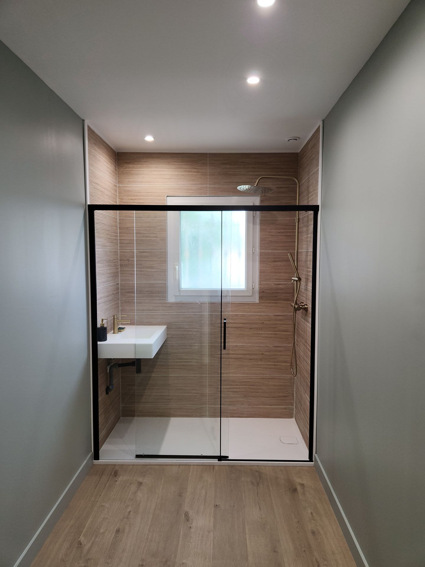 Salle de bain en bois et vitrée avec une douche à l'italienne.