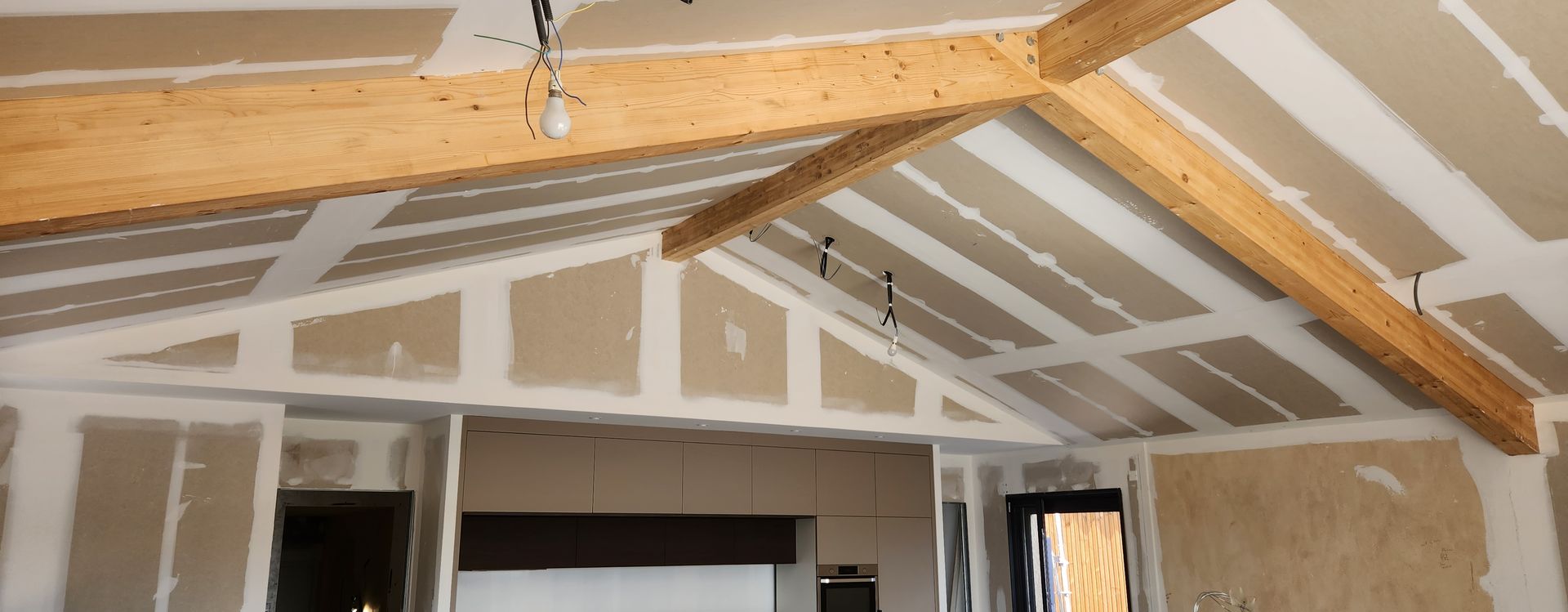 Pièce en travaux avec une charpente en bois.