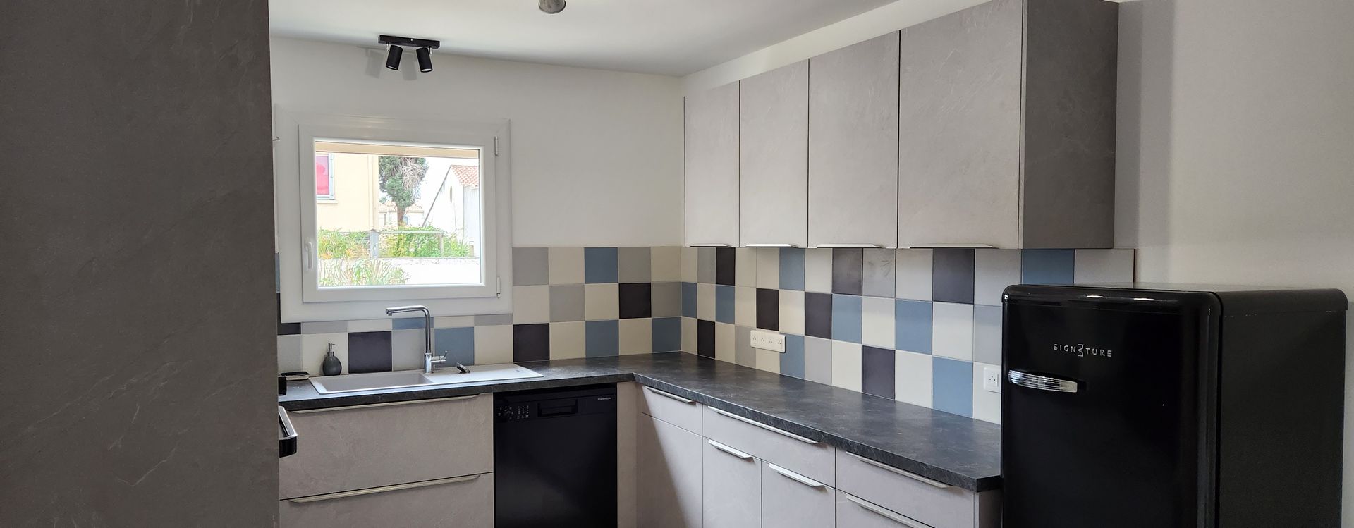 Cuisine avec meubles blancs et plan de travail gris