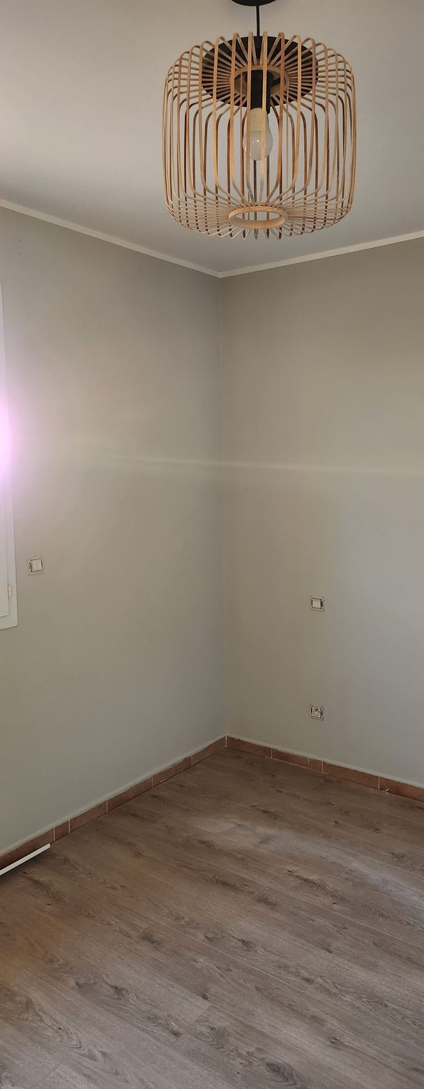Chambre avec sol en parquet et lustre suspendu