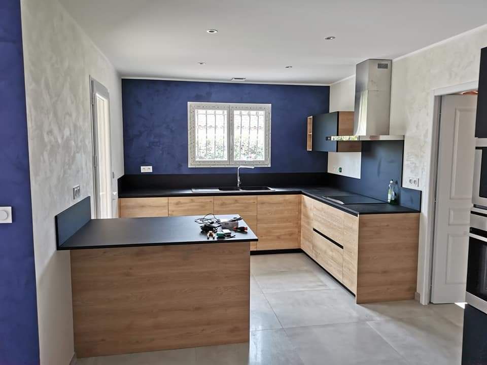 Cuisine couleur bois avec mur bleu et fenêtre