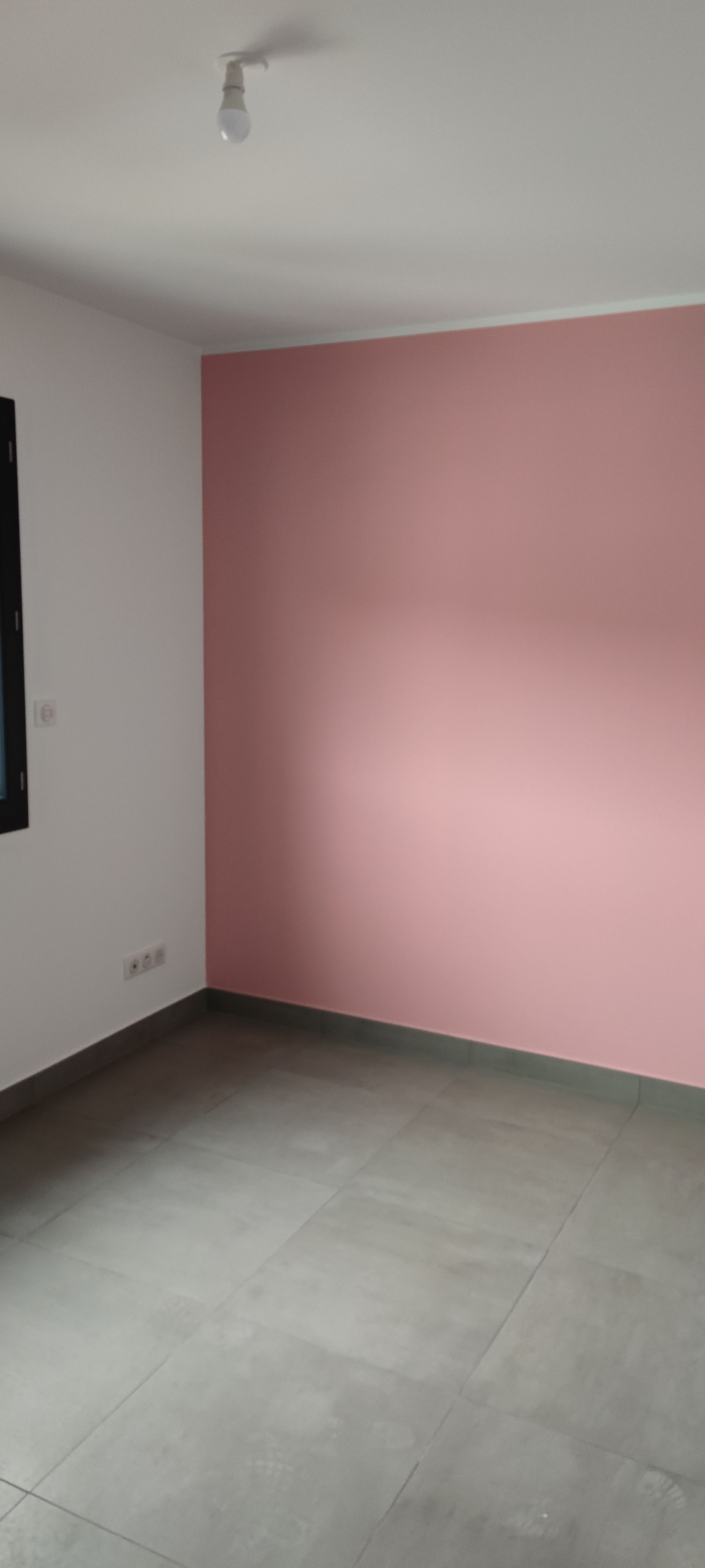 Un mur vu de coin une partie du mur rose et la deuxième partie en blanc.