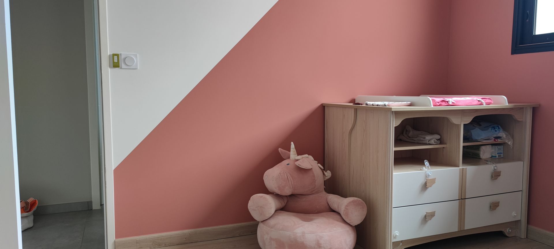 Chambre rose et blanc avec une peluche de licorne Rose.