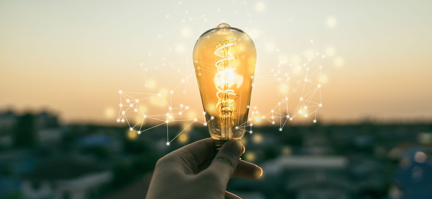 Une personne tenant une ampoule allumée.