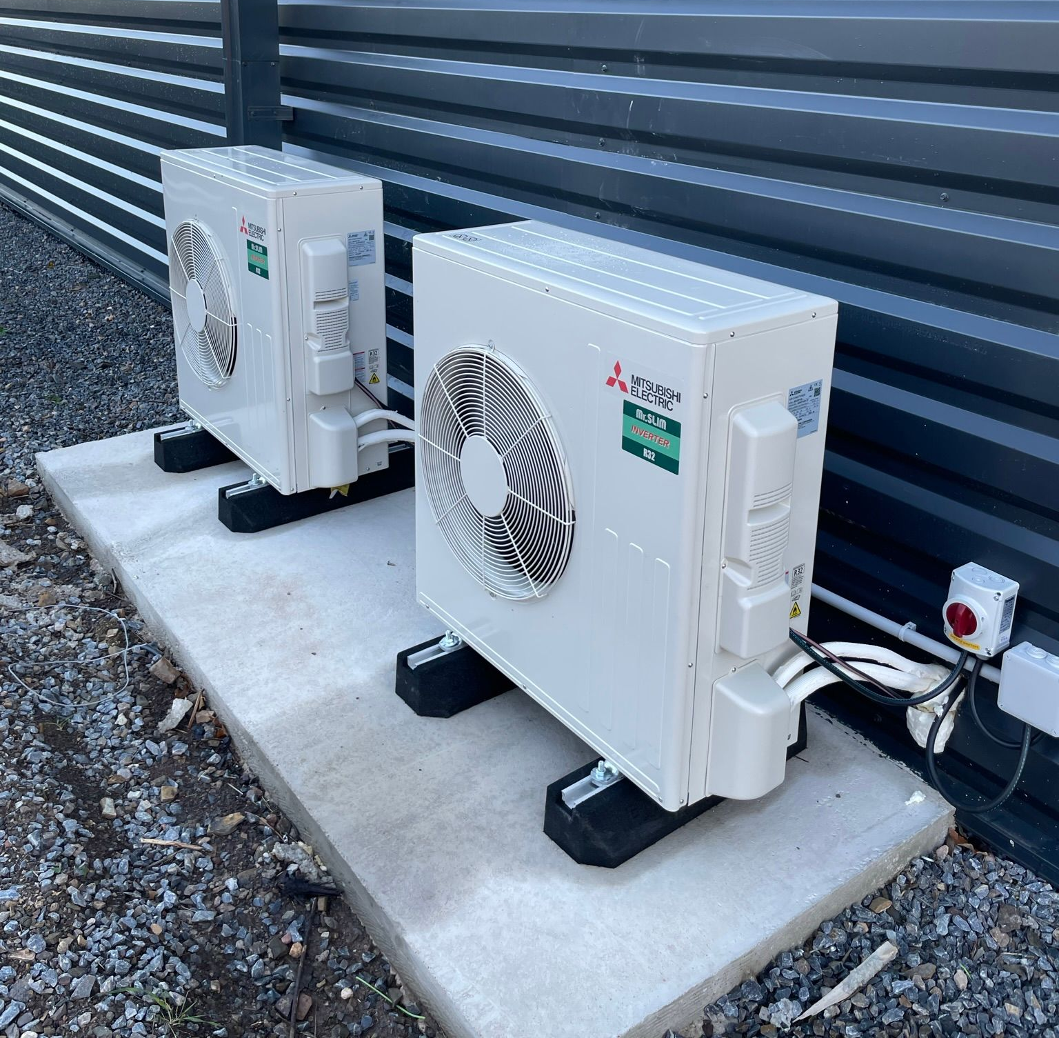 Deux unités de climatisation sur une dalle de béton.