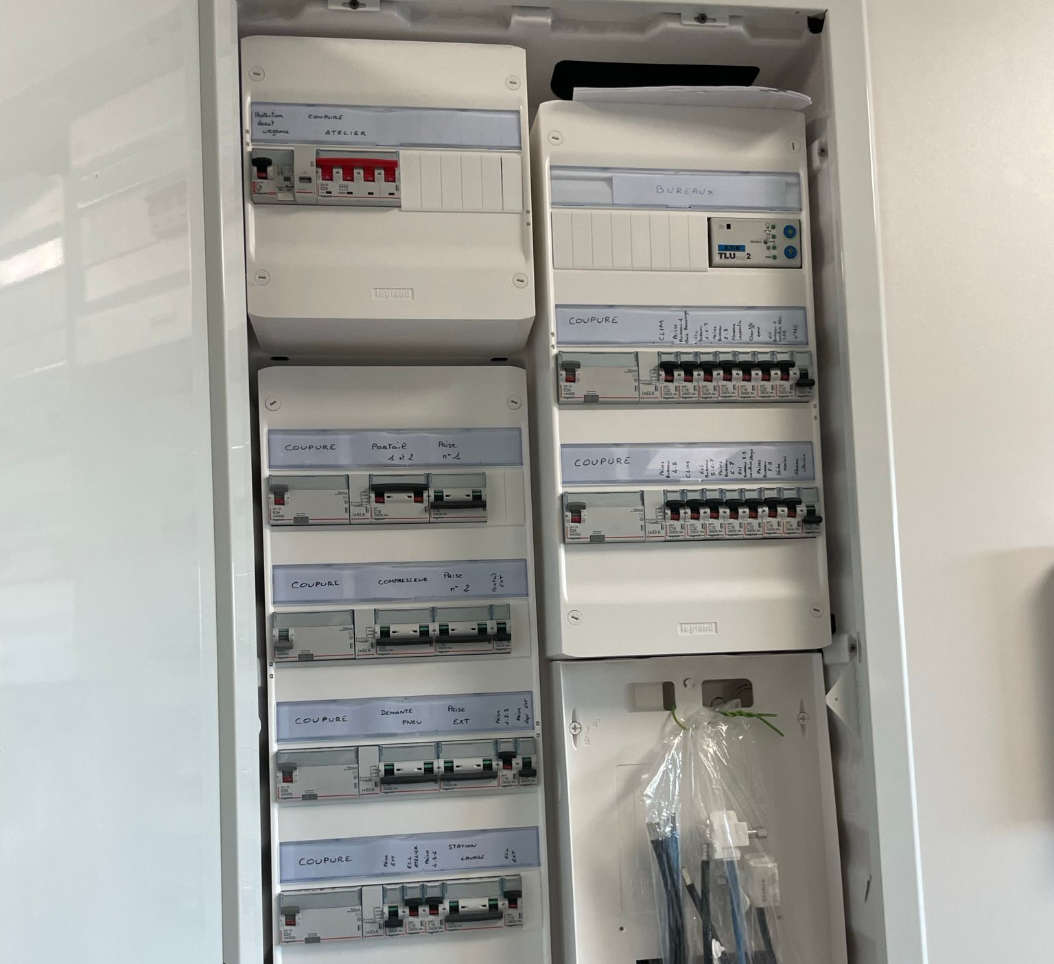 Tableau électrique comportant plusieurs rangées de disjoncteurs.