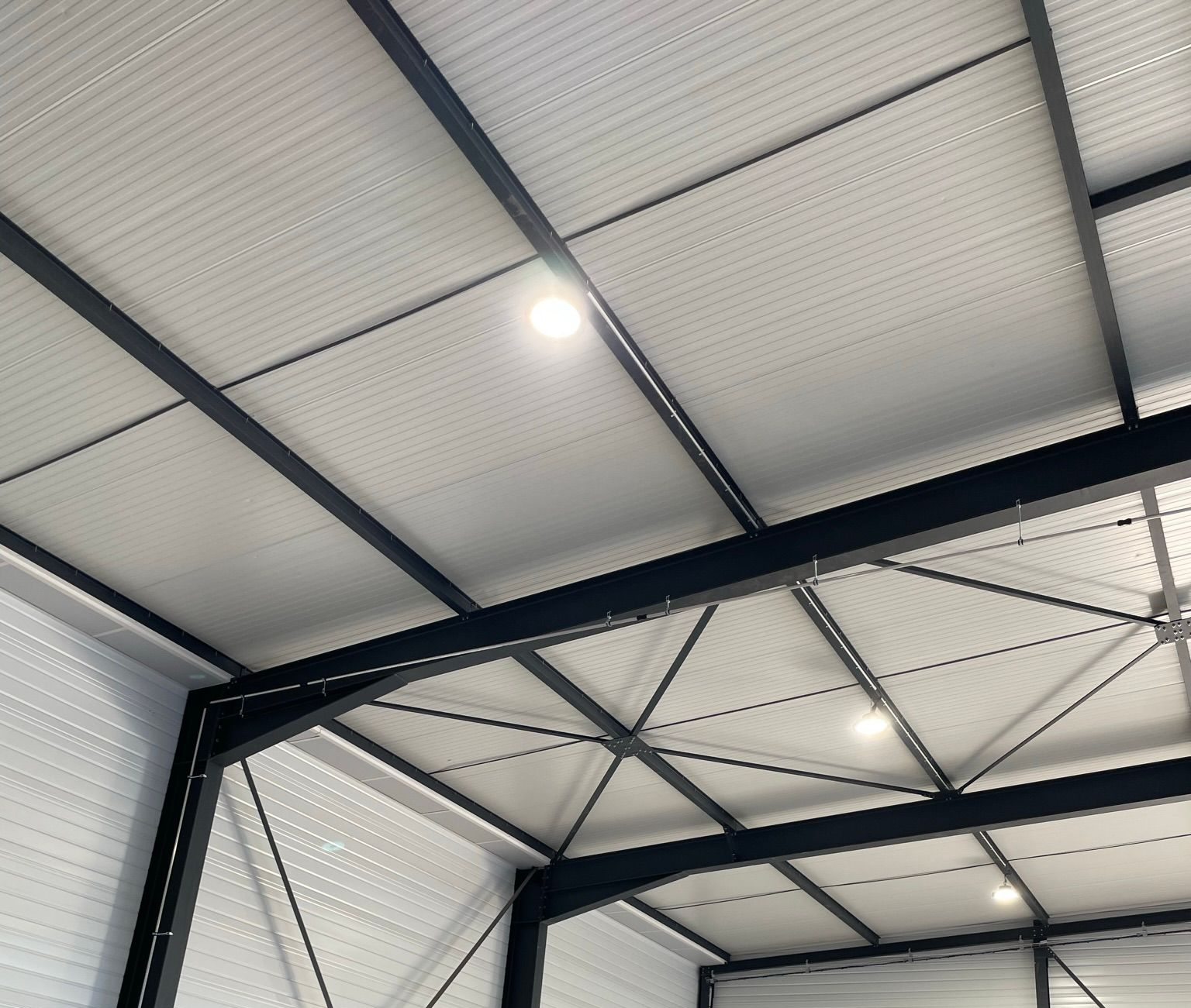 Vue intérieure d'un bâtiment soutenu par des poutres en acier noir.