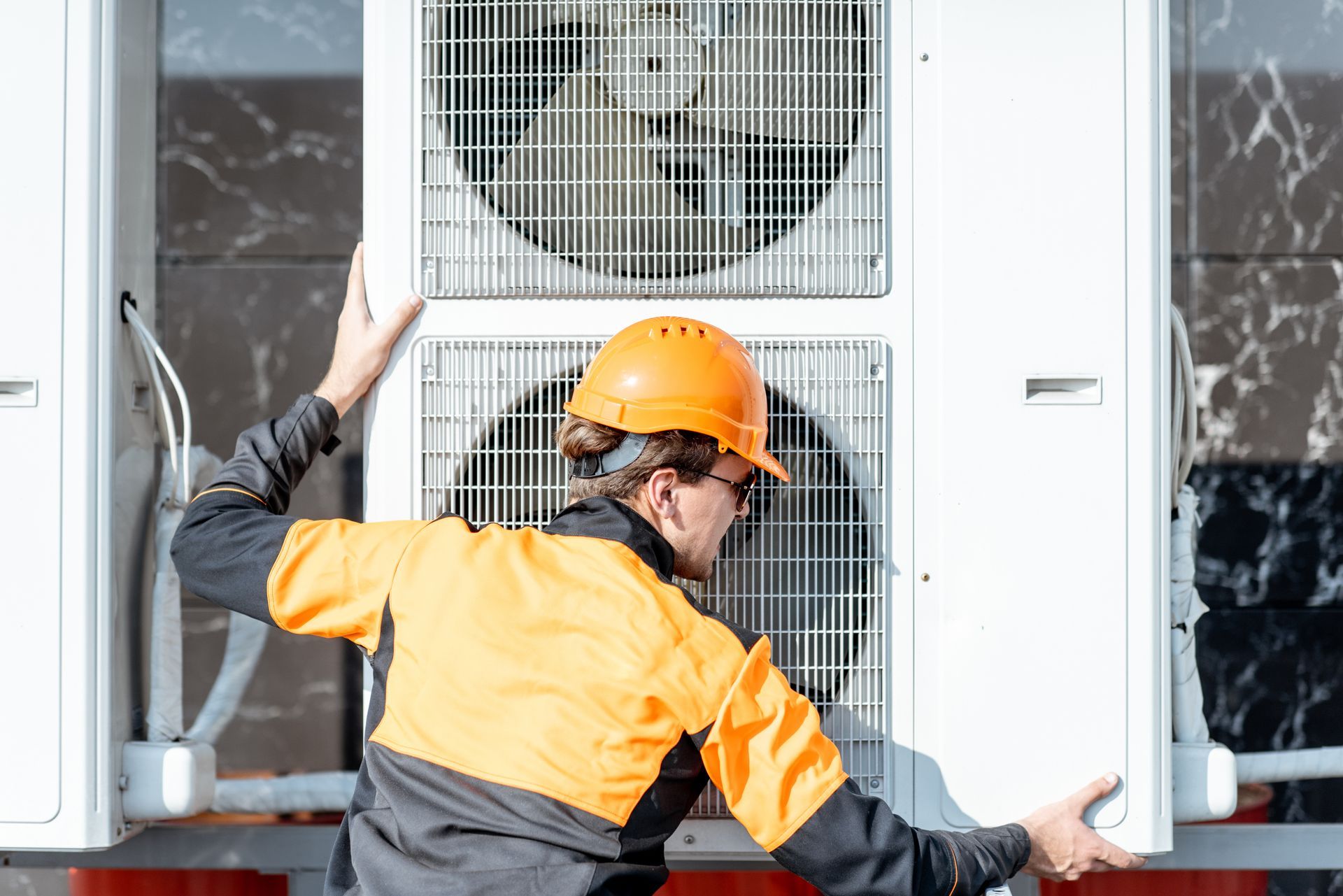 Homme qui met en place une pompe à chaleur