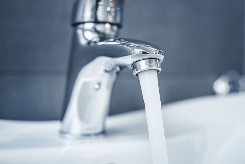 Robinet chromé laissant couler de l'eau