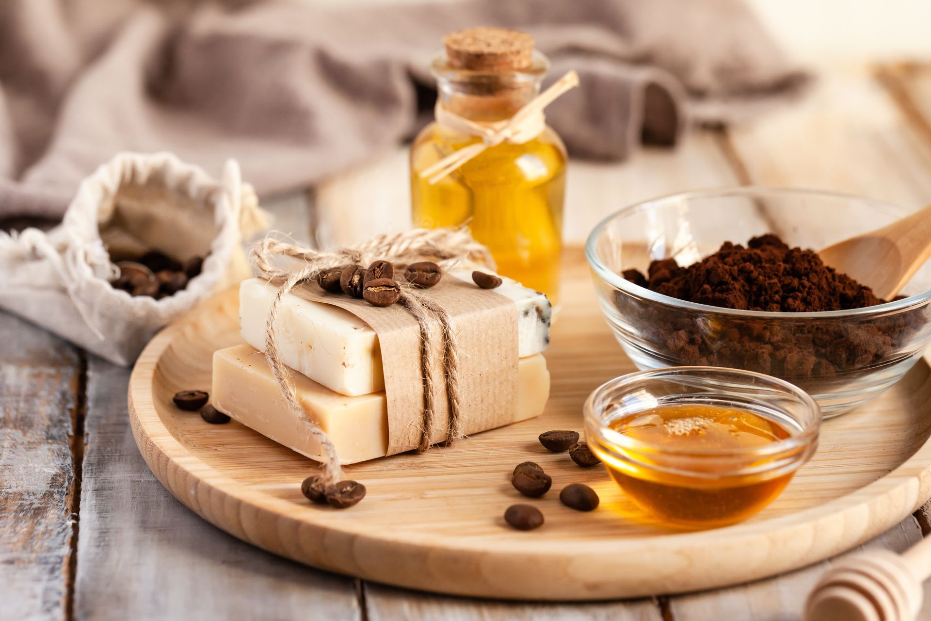 Savon naturel au miel, au marc de café et à l'huile, présenté sur une planche en bois.