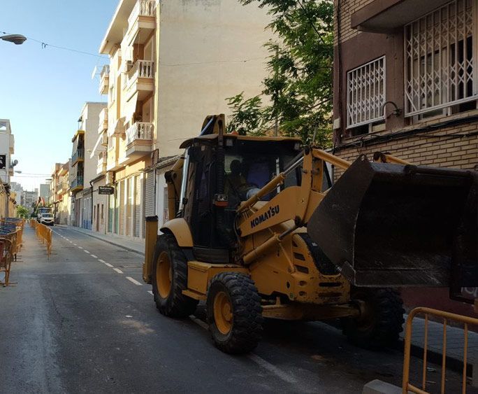 Una excavadora Komatsu está estacionada al costado de la carretera.