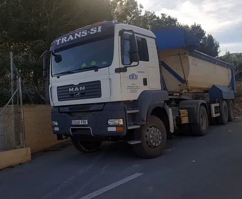 Un camión volquete está estacionado al costado de la carretera.