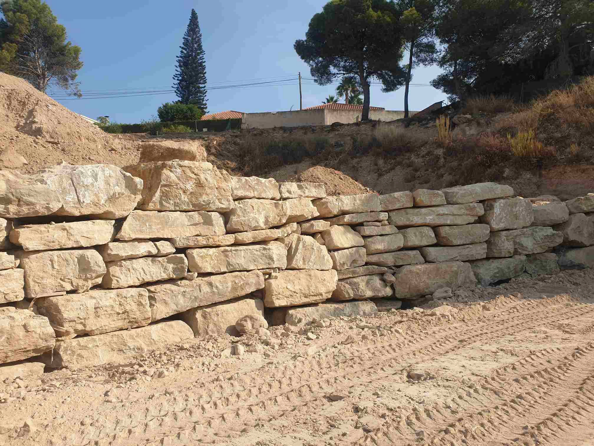 Una gran pila de rocas se encuentra en la cima de una colina de tierra.