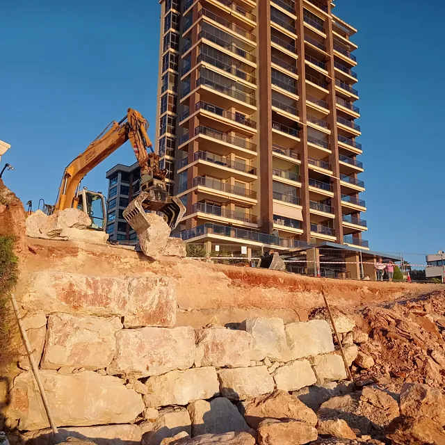 Un sitio de construcción con un gran edificio al fondo.