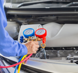 Un homme travaille sur le moteur d'une voiture.