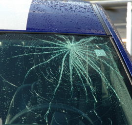 Une voiture bleue et blanche avec un pare-brise cassé