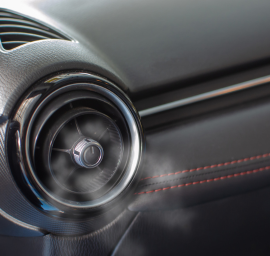 Un gros plan d'une grille d'aération de voiture avec de la vapeur qui en sort