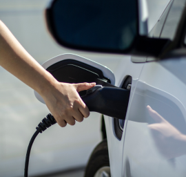 Une personne charge une voiture électrique avec un chargeur