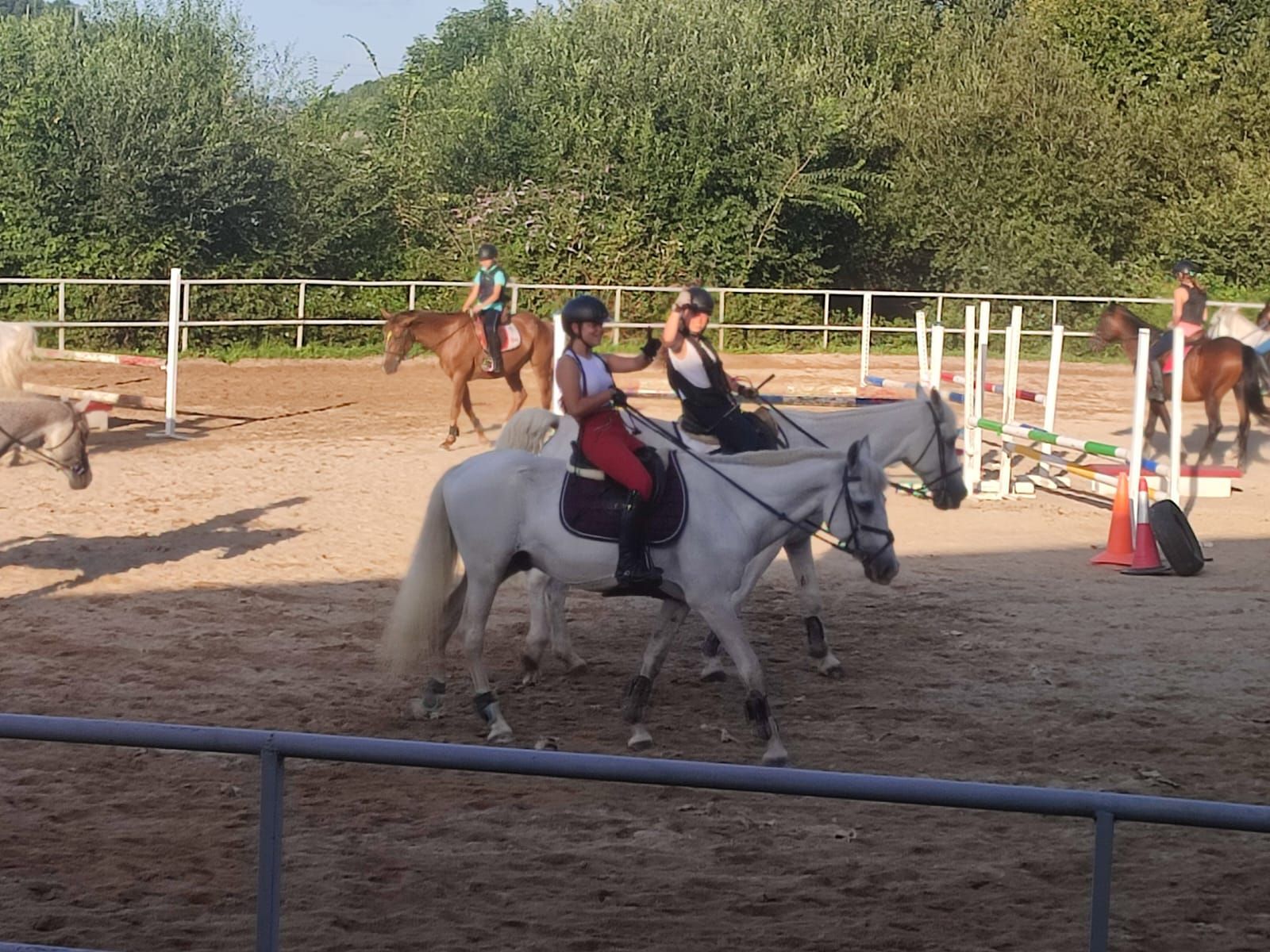 Un grupo de personas monta a caballo en una zona vallada.