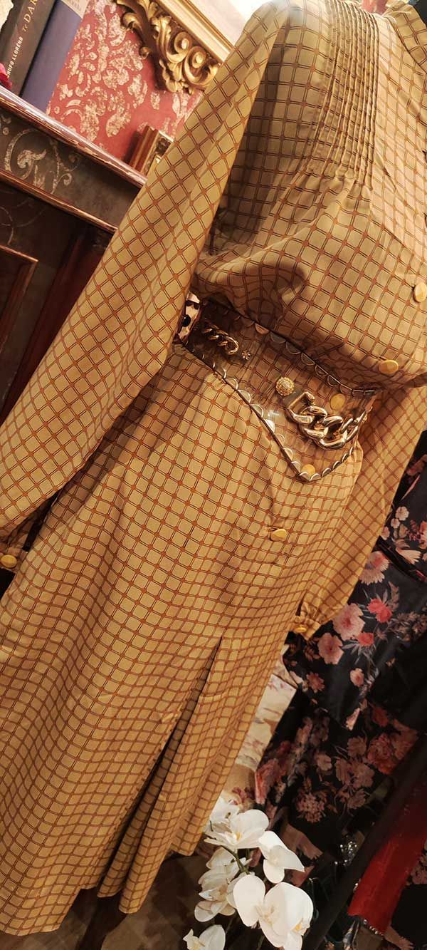 Vestido estampado color canela con cinturón dorado.