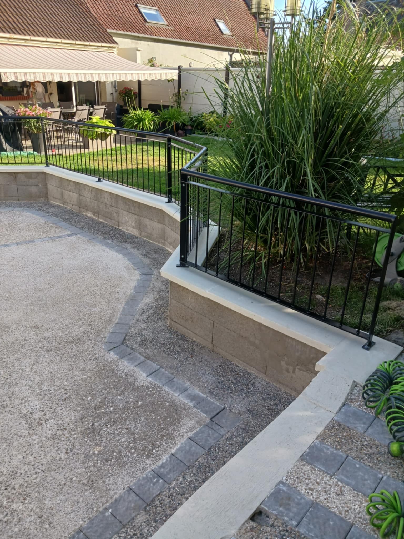 Mur de soutènement avec une clôture noire