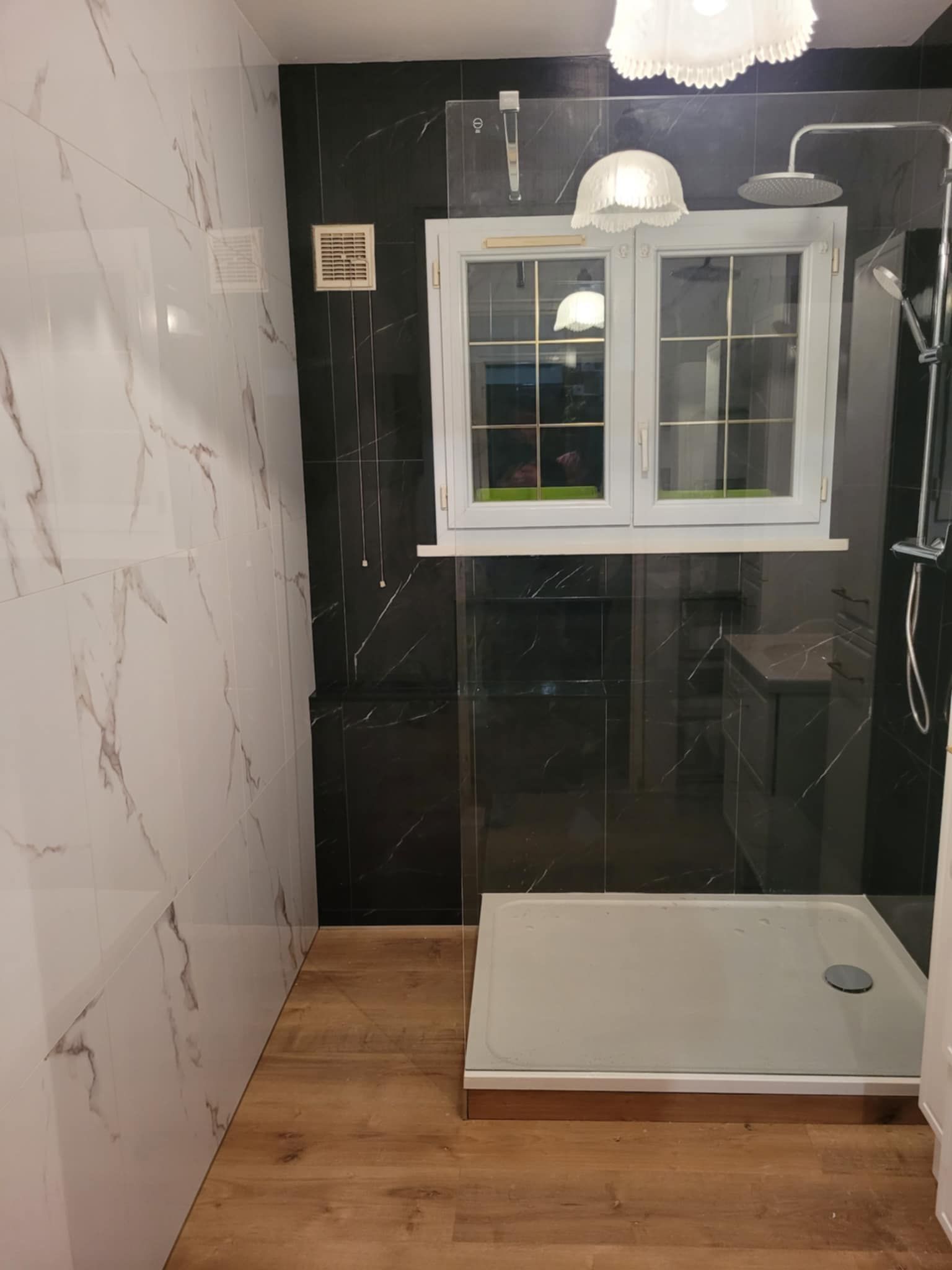 Douche italienne dans une salle de bains aux murs imitation marbre