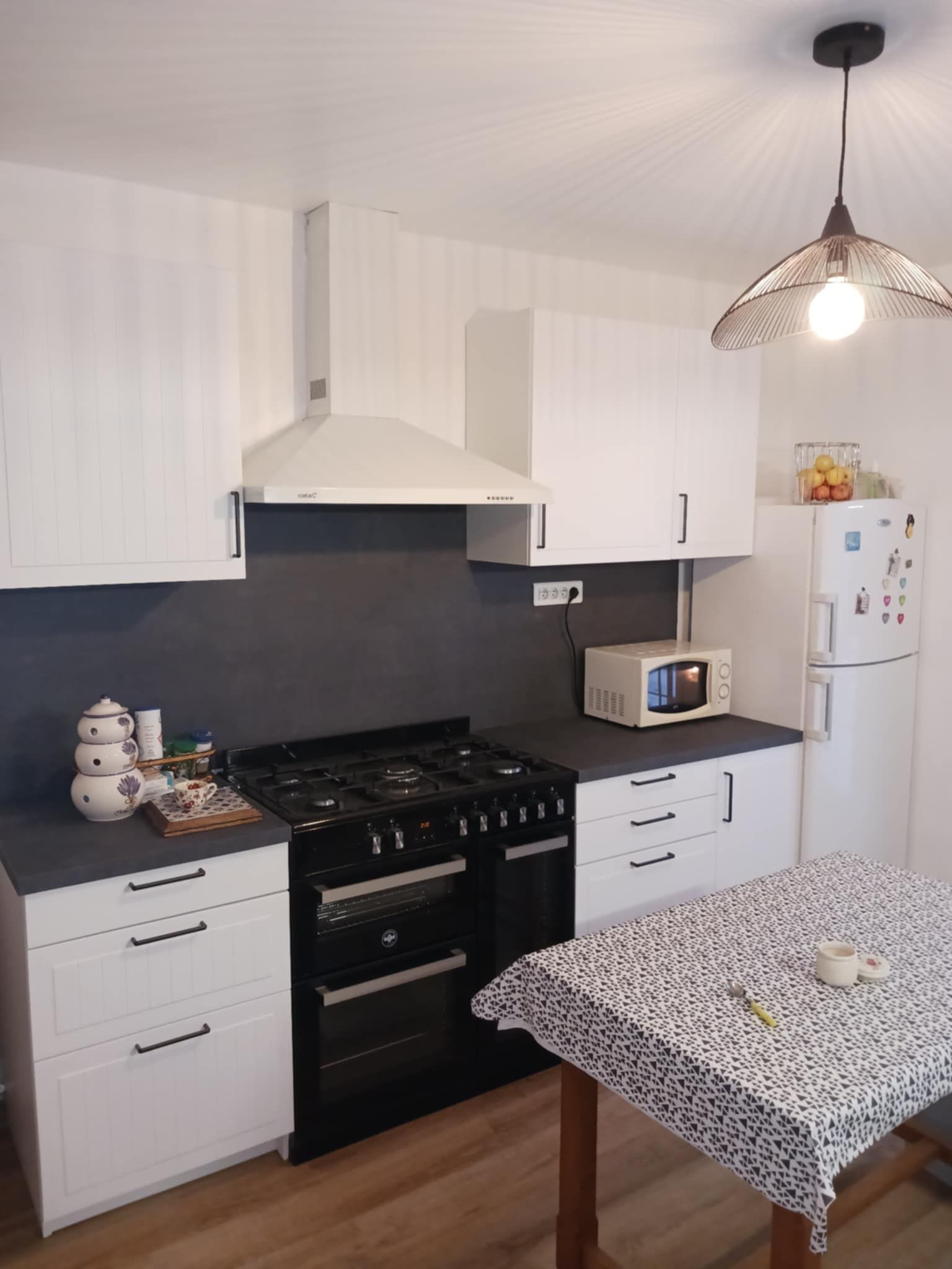 Cuisine avec des meubles blancs et un plan de travail gris