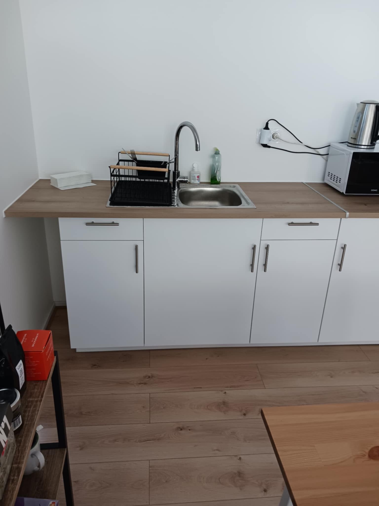 Cuisine avec des meubles blancs et un plan de travail en bois