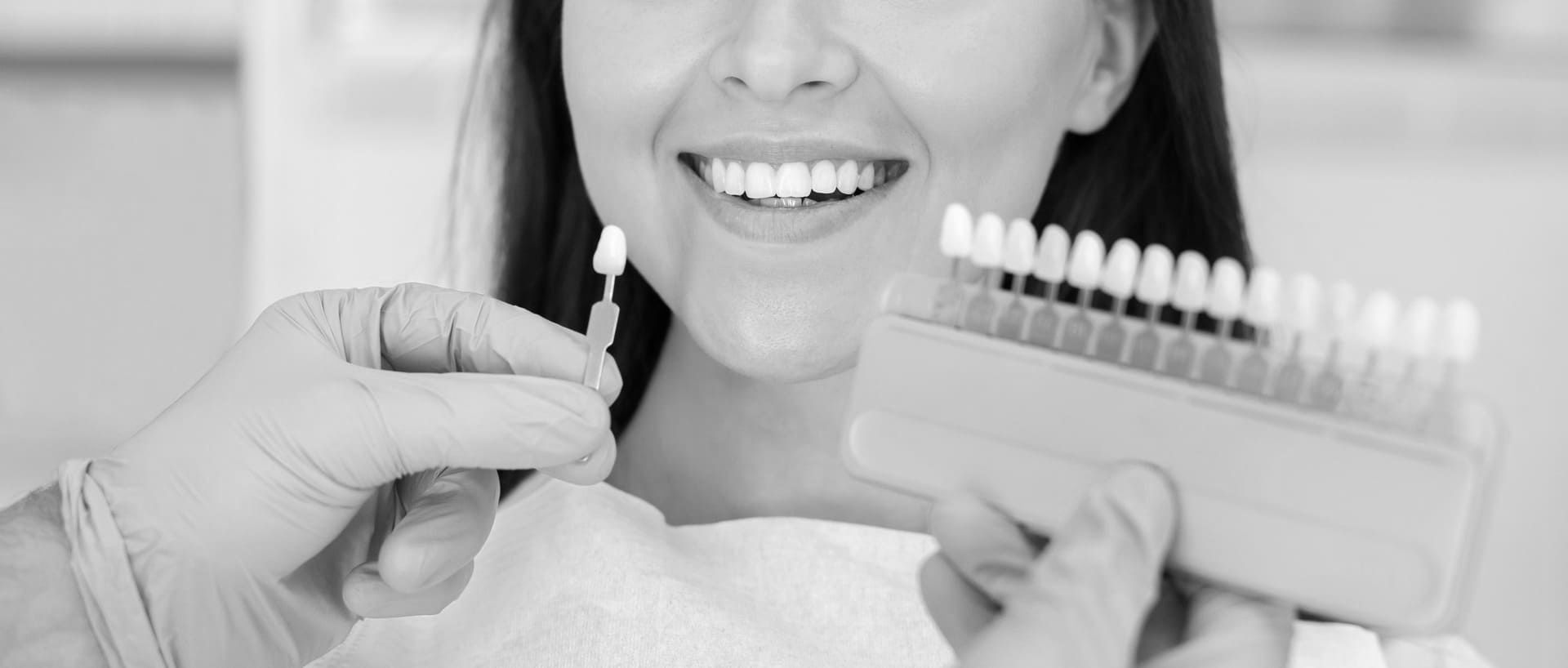 Una mujer se está blanqueando los dientes con un dentista.
