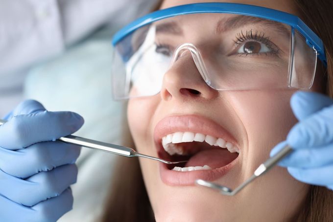 Una mujer está siendo examinada por un dentista.