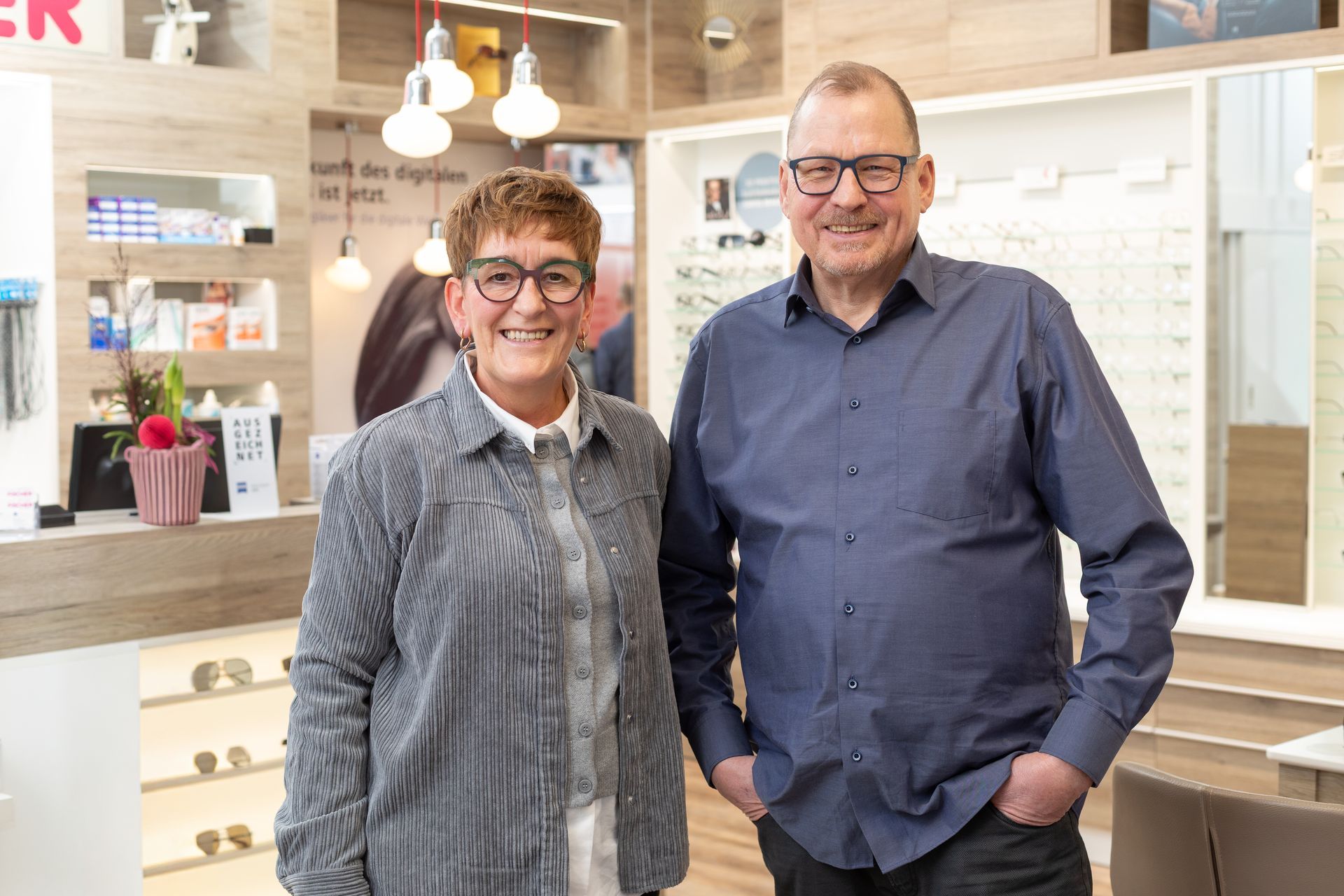 Mehrere Brillenpaare auf einer Holzoberfläche, verschiedene Farben und Stile.