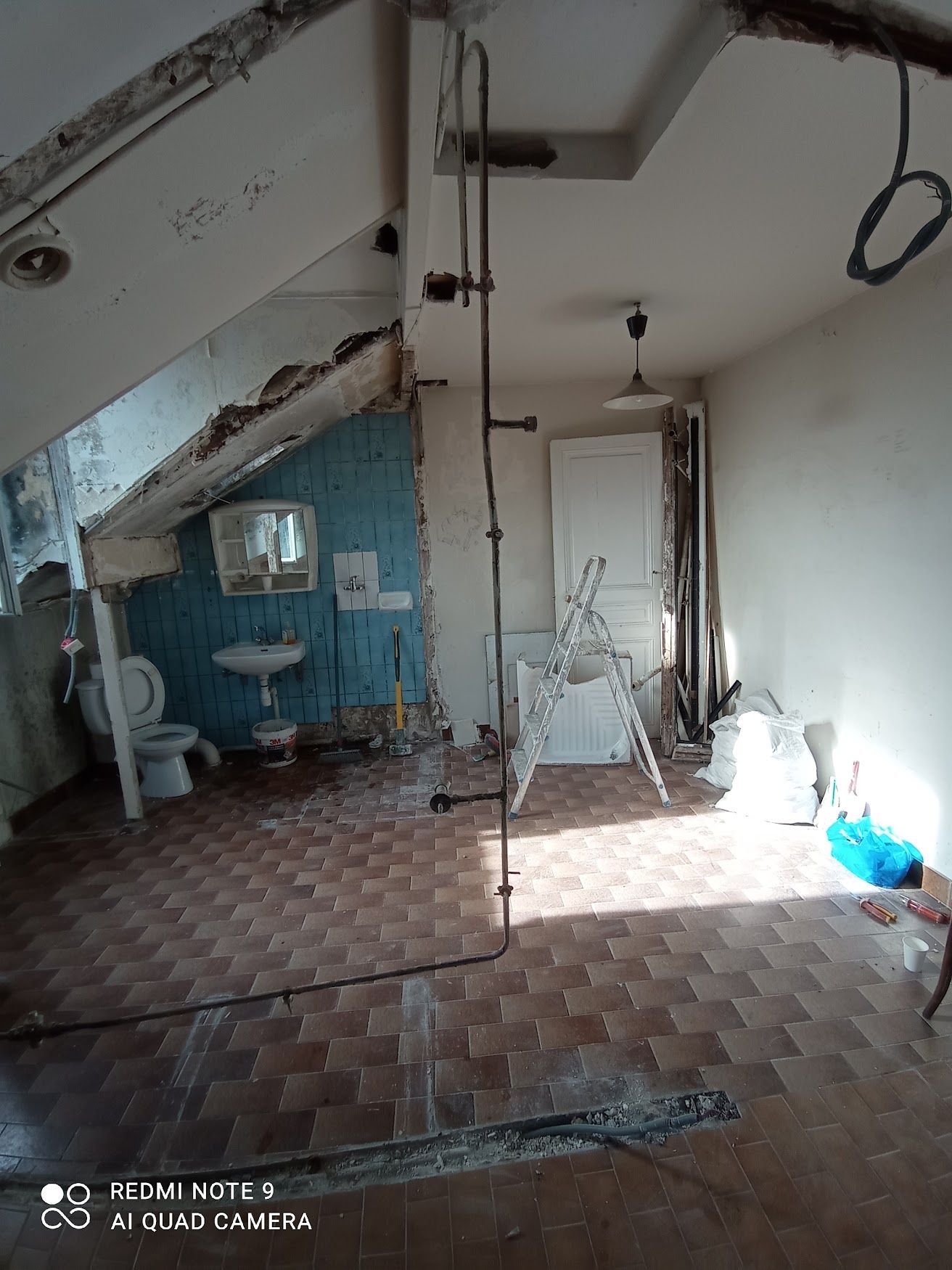 Salle de bains avec mur cassé 