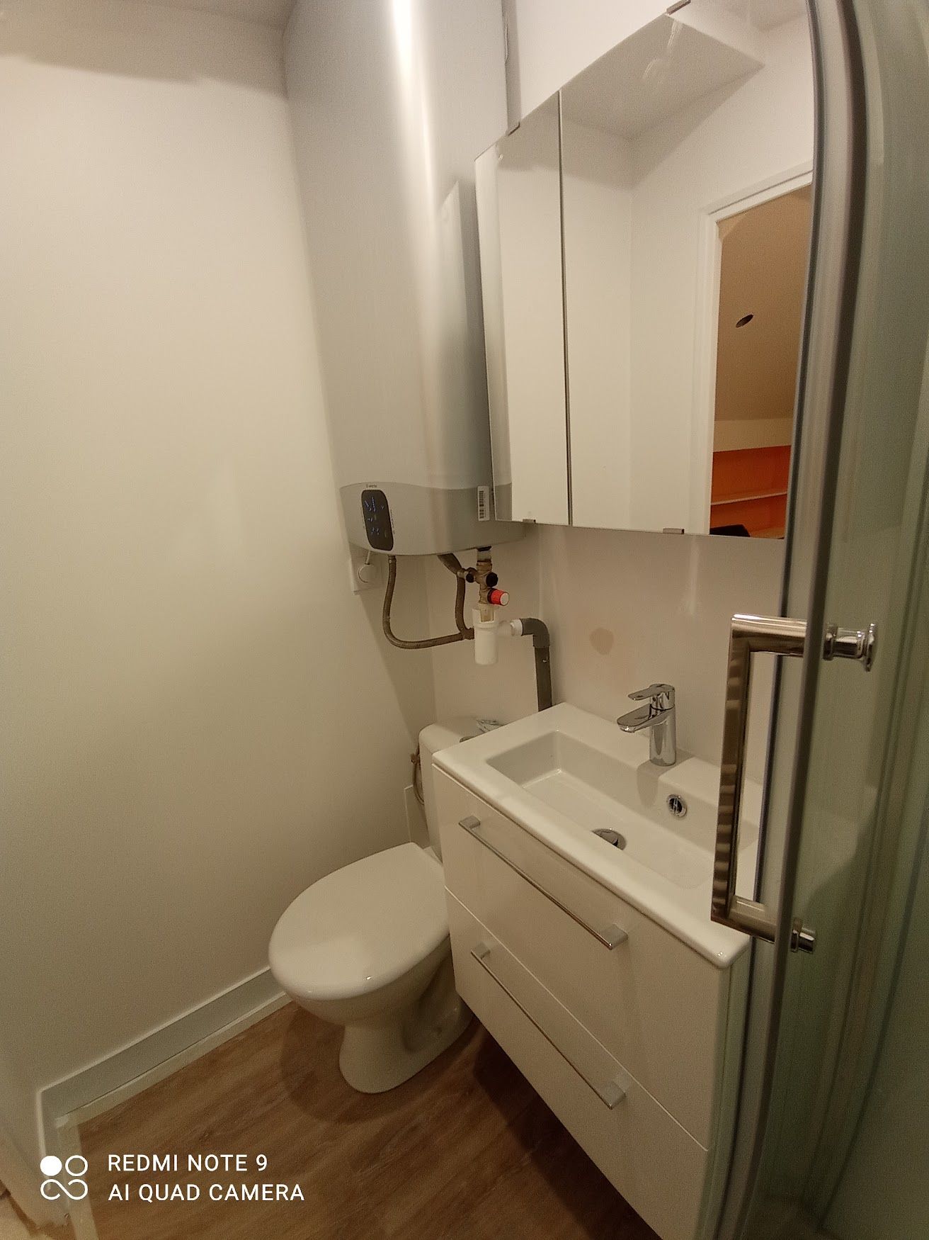 Salle de bains avec meuble vasque, wc et douche