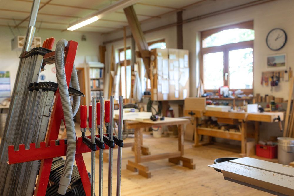 Eine Tischlerwerkstatt mit einer Leiter und einer Uhr an der Wand.