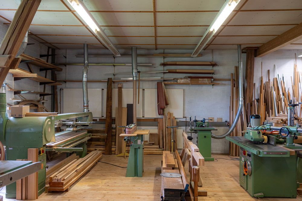 Eine Tischlerei mit viel Holz und Maschinen.
