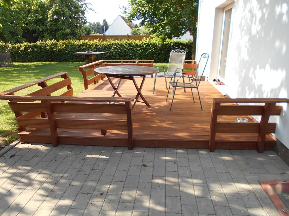 Eine Holzterrasse mit einem Tisch und Stühlen darauf