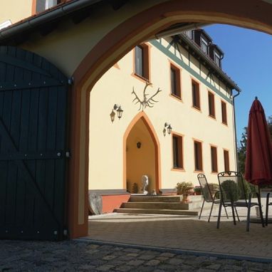 Blick durch einen Torbogen auf die Pension Jagdschlössl
