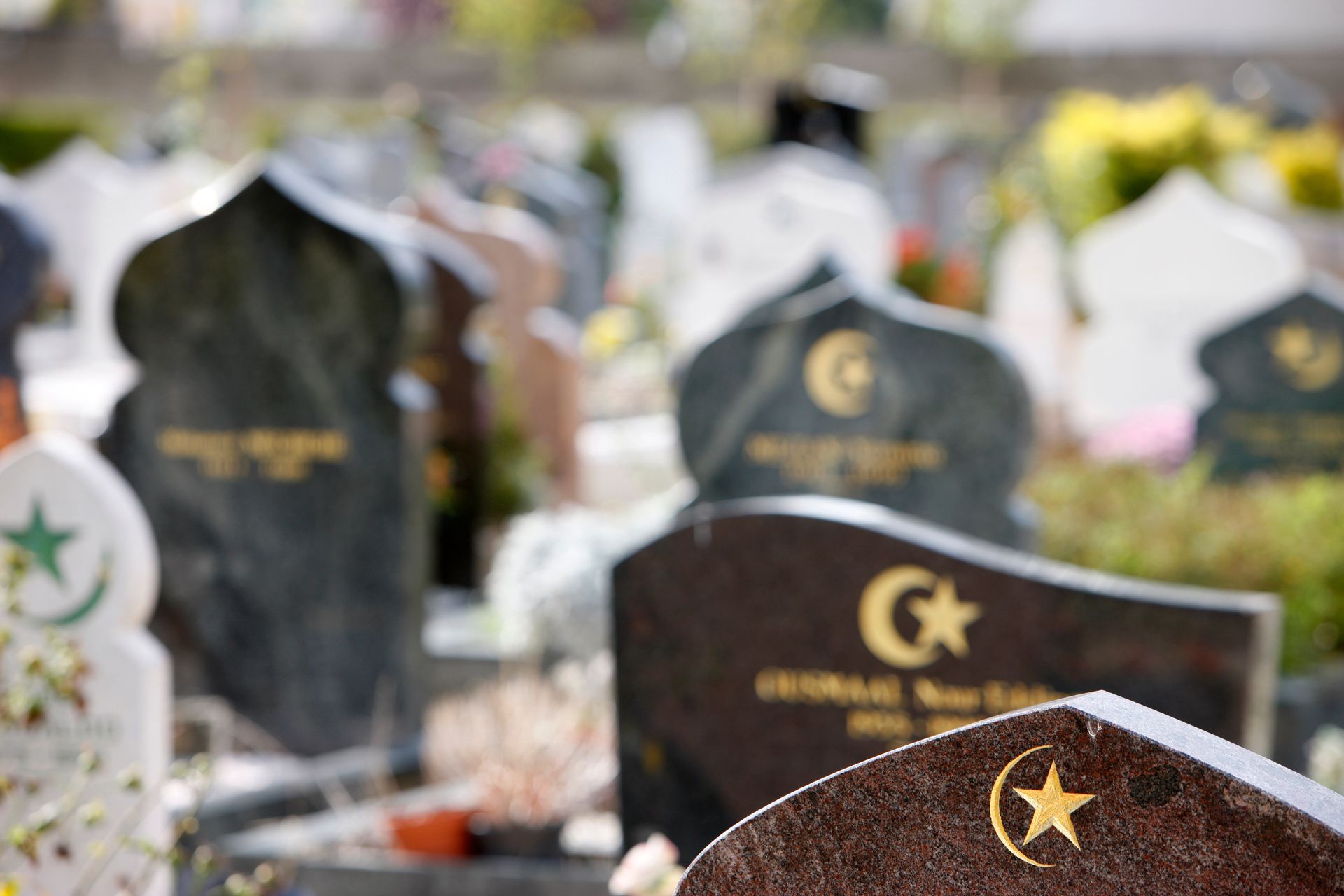 Pierres tombales dans un cimetière islamique, avec des croissants de lune et des étoiles gravés sur les pierres.