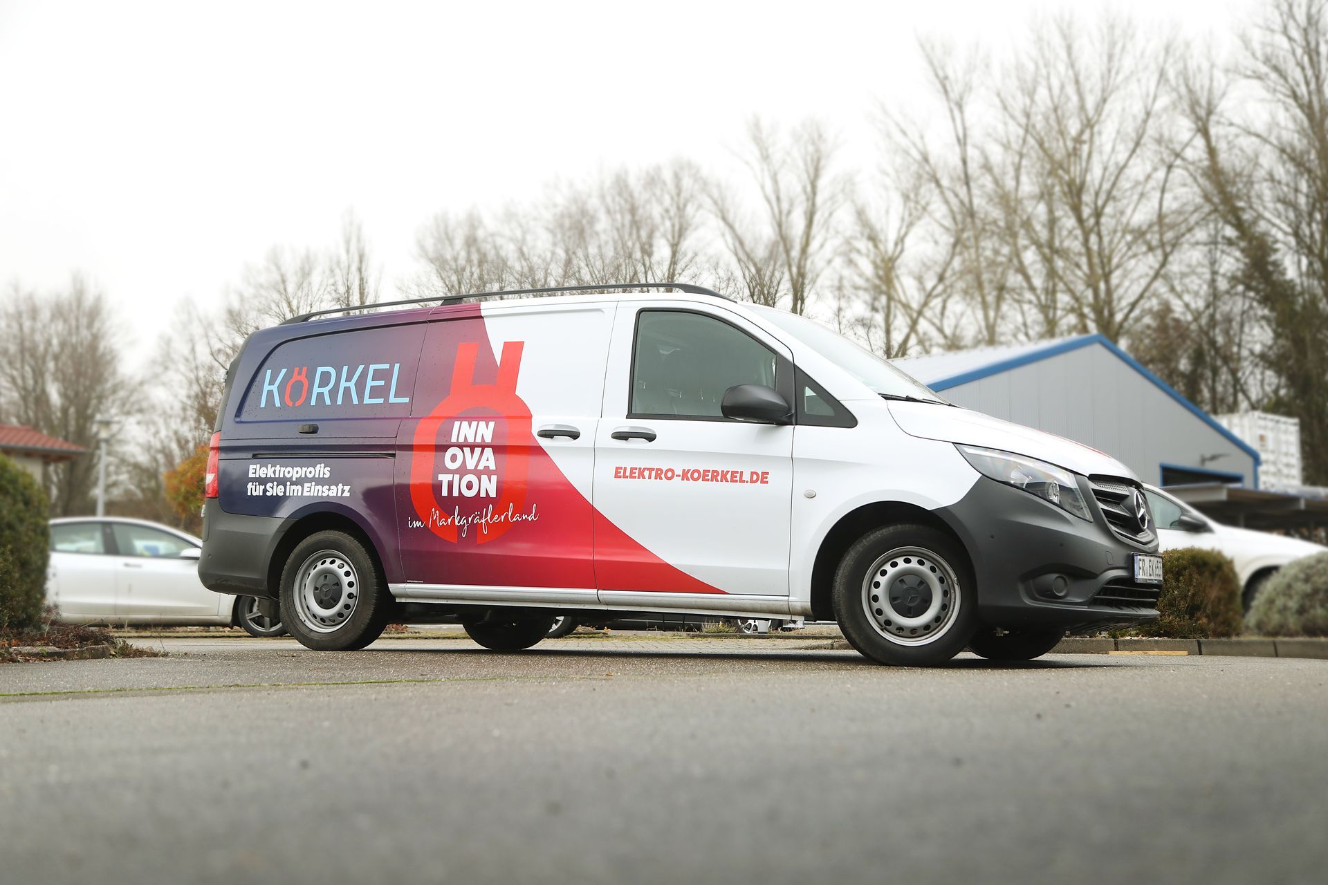 Eine Gruppe von Menschen in blauen Kapuzenpullovern und Jeans posiert in einem Innenraum.