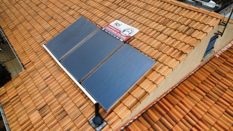 Panneaux solaires installés sur un toit de tuiles en terre cuite.