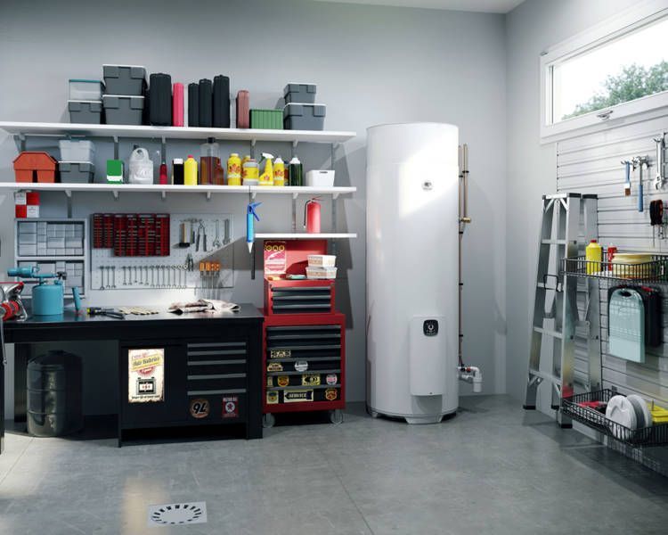 Un garage propre et bien organisé, avec chauffe-eau, établi, étagères et outils.