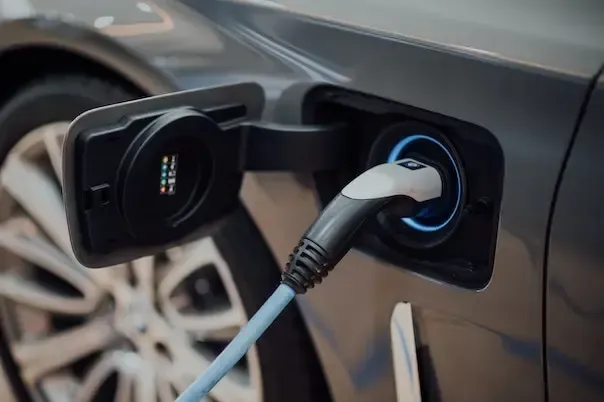Câble de recharge pour voiture électrique branché sur la prise de recharge du véhicule, gros plan