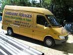 Une camionnette jaune portant l'inscription « Gardenne Forages » est garée près de tuyaux métalliques.