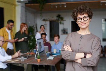 Woman giving presentation to attentive audience in a classroom setting.