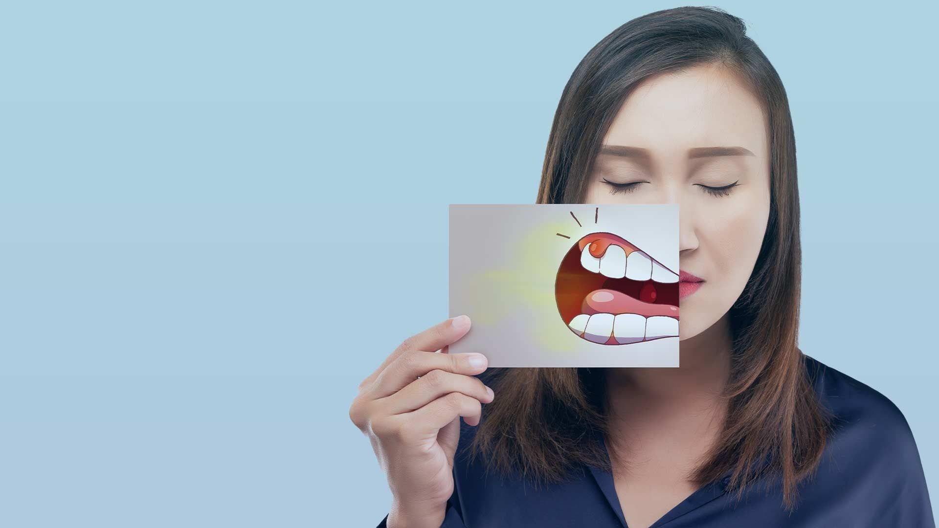 Una mujer sostiene una fotografía de sus dientes delante de su cara.