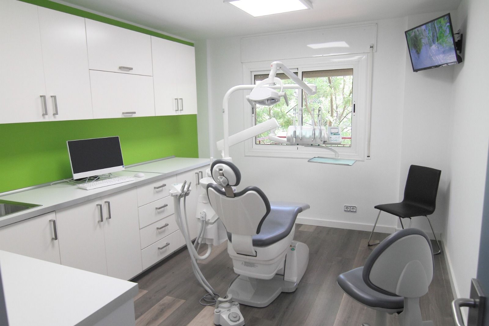 Un consultorio dental con un sillón dental y una computadora.
