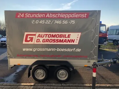 An einer blauen Wand sind Werkzeuge übersichtlich angeordnet: Schraubenschlüssel, Messschieber und andere Handwerkzeuge.
