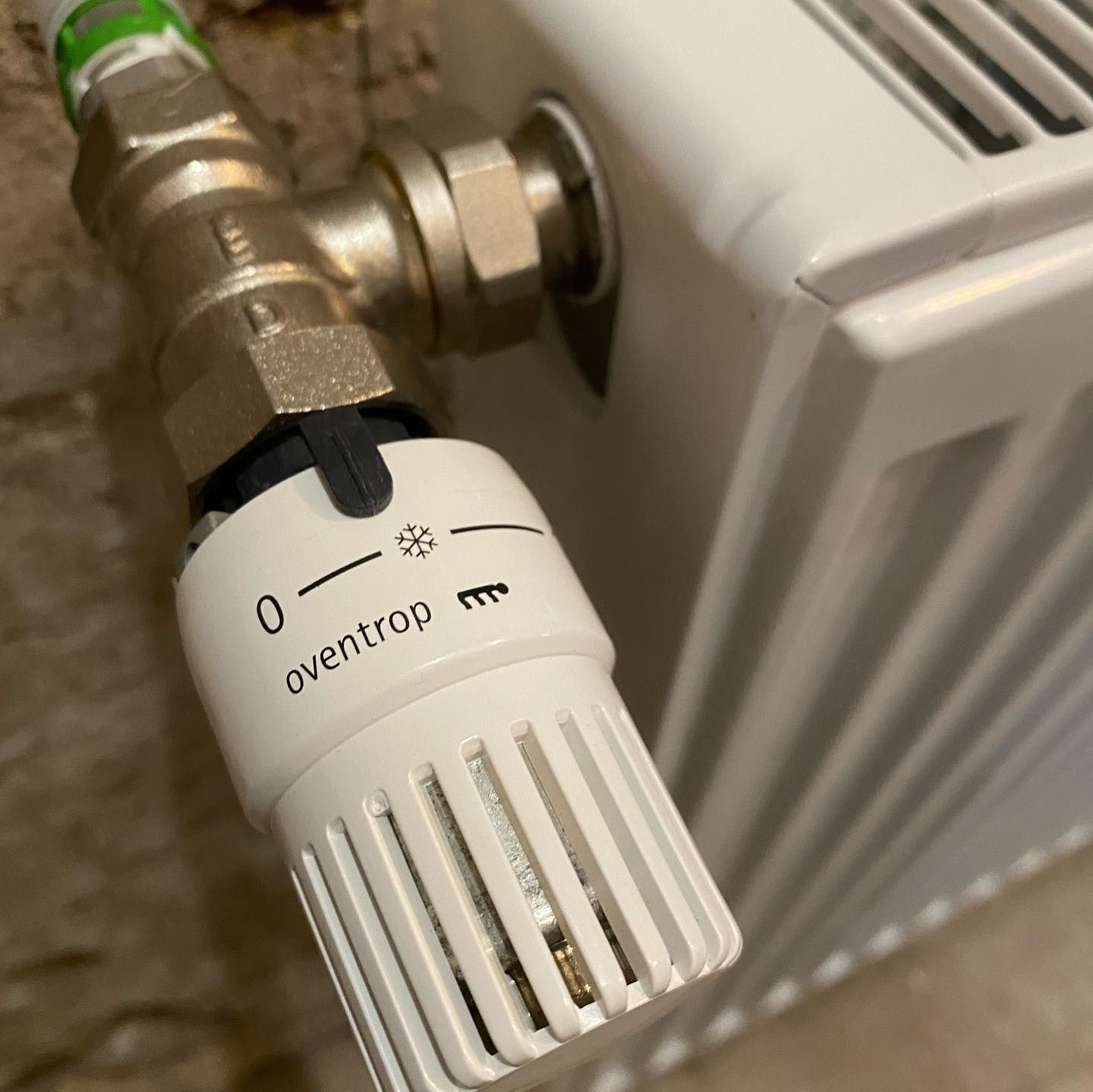 Robinet thermostatique de radiateur Oventrop blanc, réglé sur le symbole de protection antigel